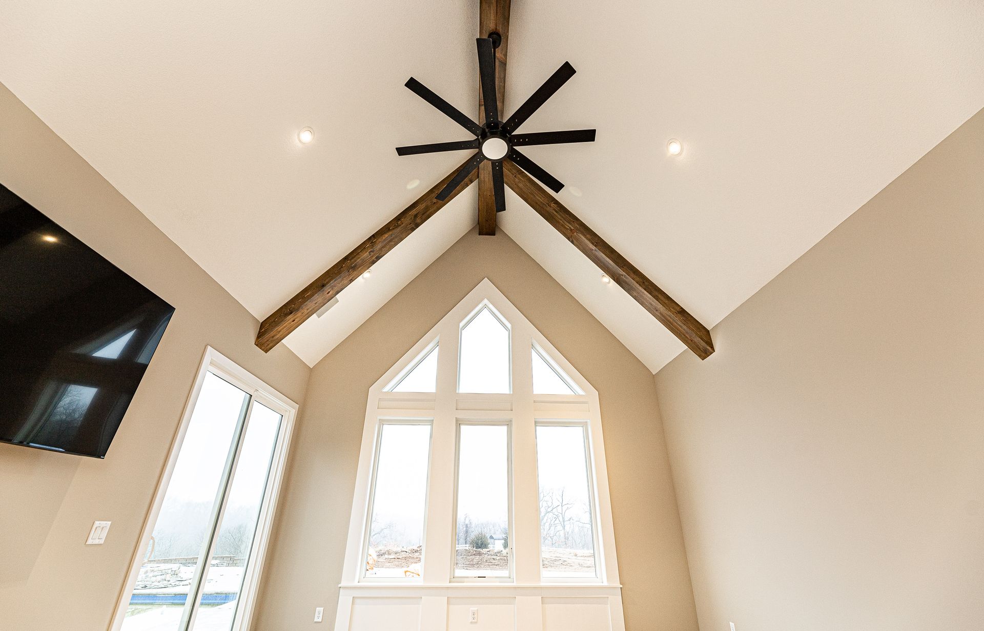 A living room with a vaulted ceiling and a ceiling fan.