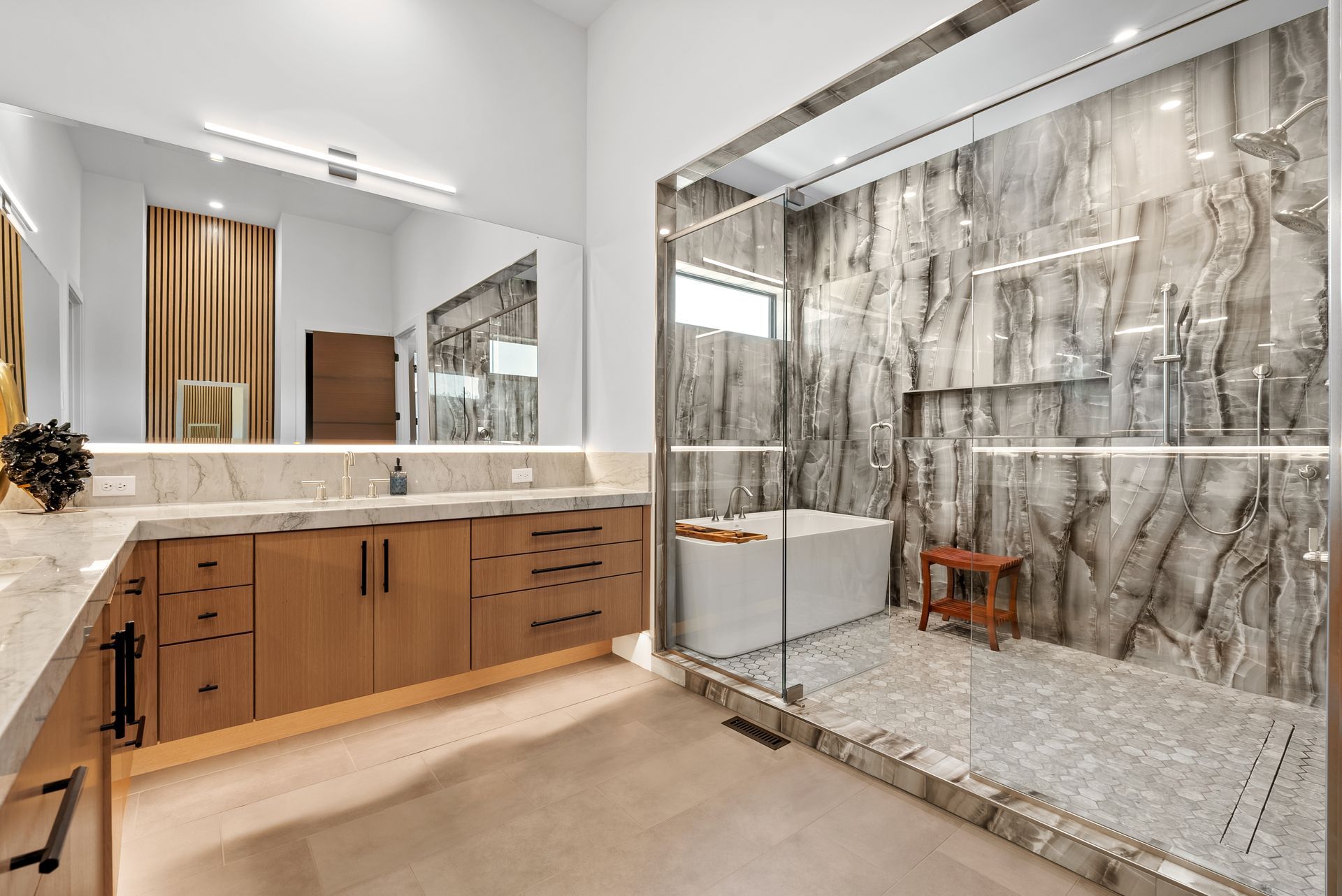 Modern bathroom with marble shower, soaking tub, wood vanity, and large mirror.