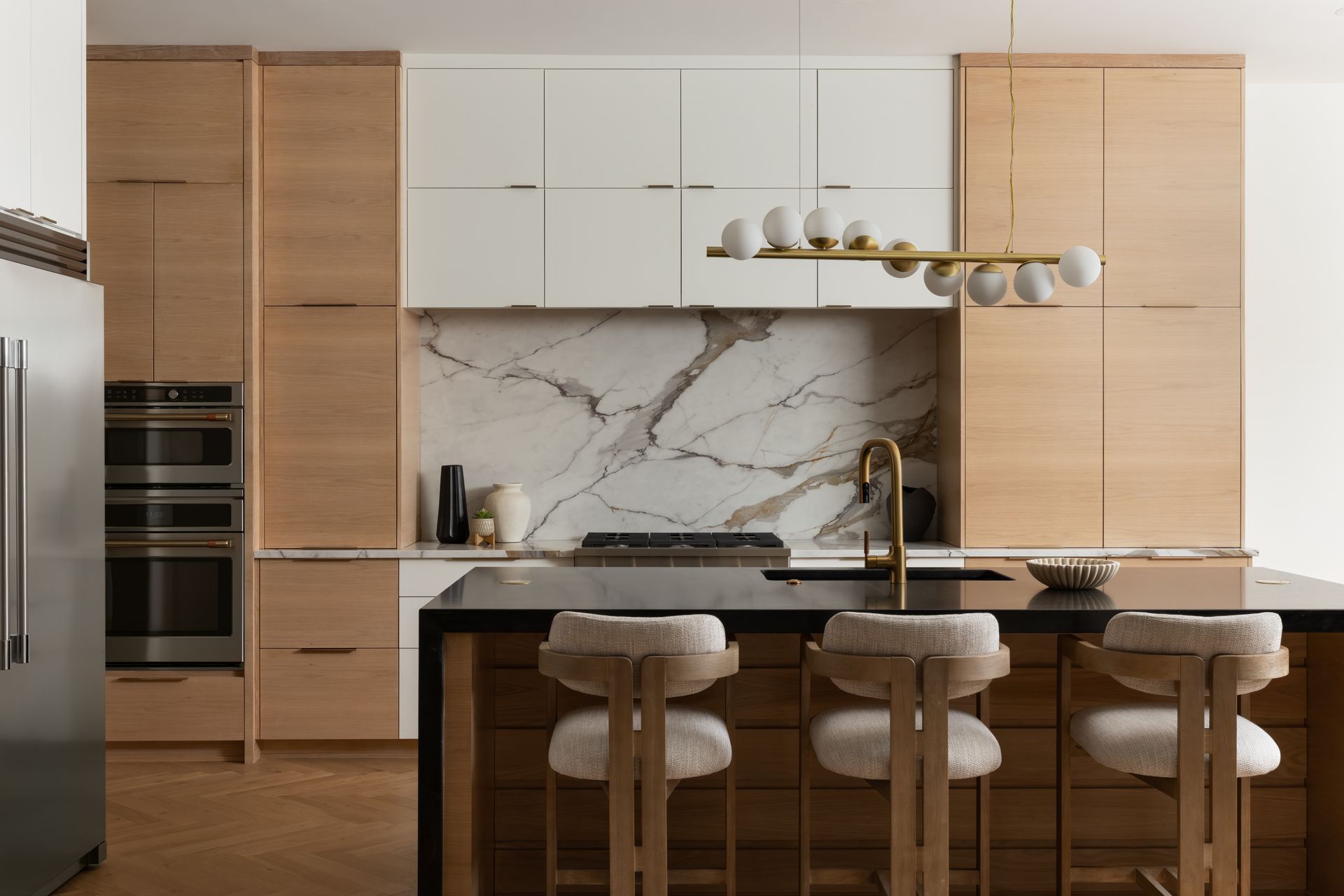 Modern kitchen with wood cabinets, marble backsplash, and island with bar stools.
