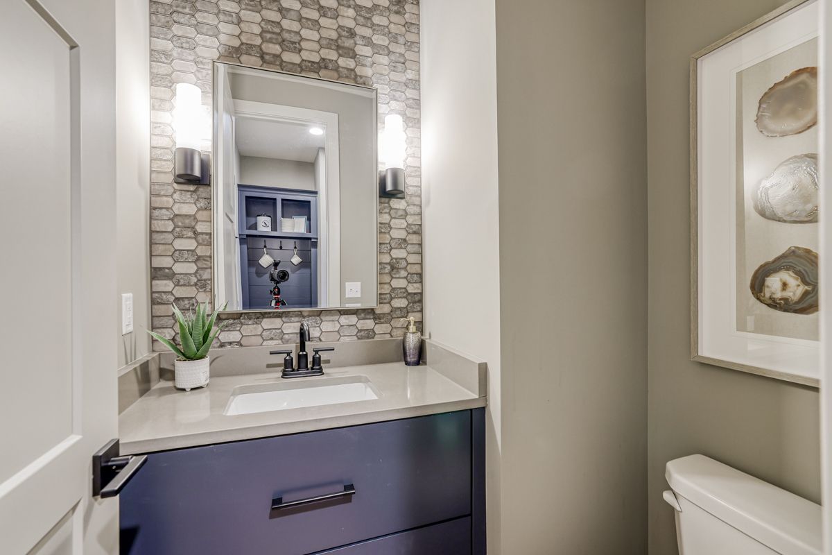 A bathroom with a sink , mirror and toilet.