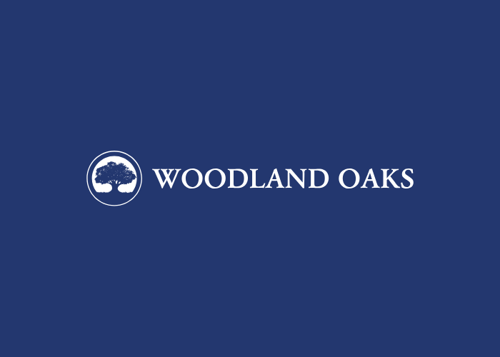The logo for woodland oaks is on a blue background