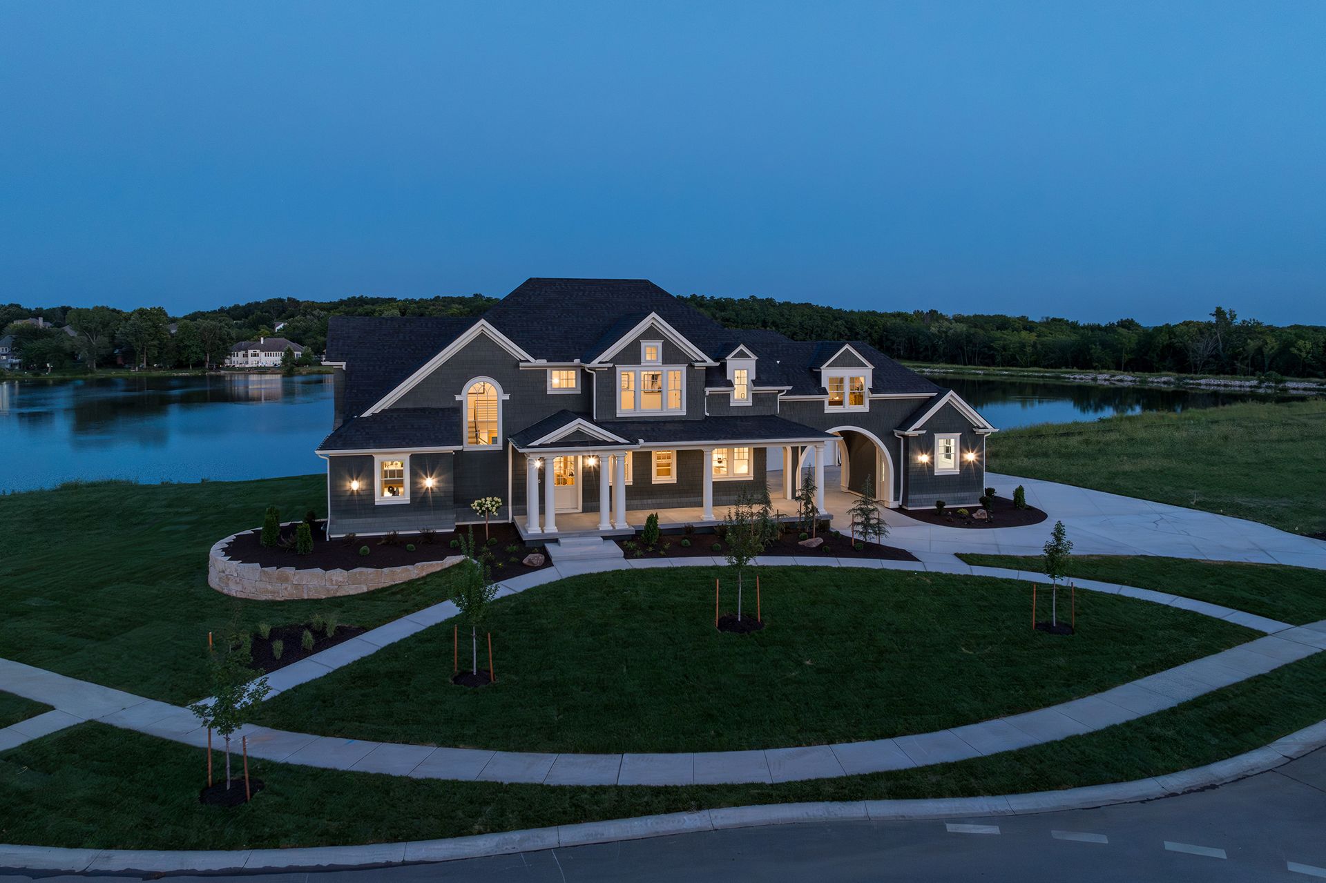 An aerial view of a large house with a lake in the background at night.