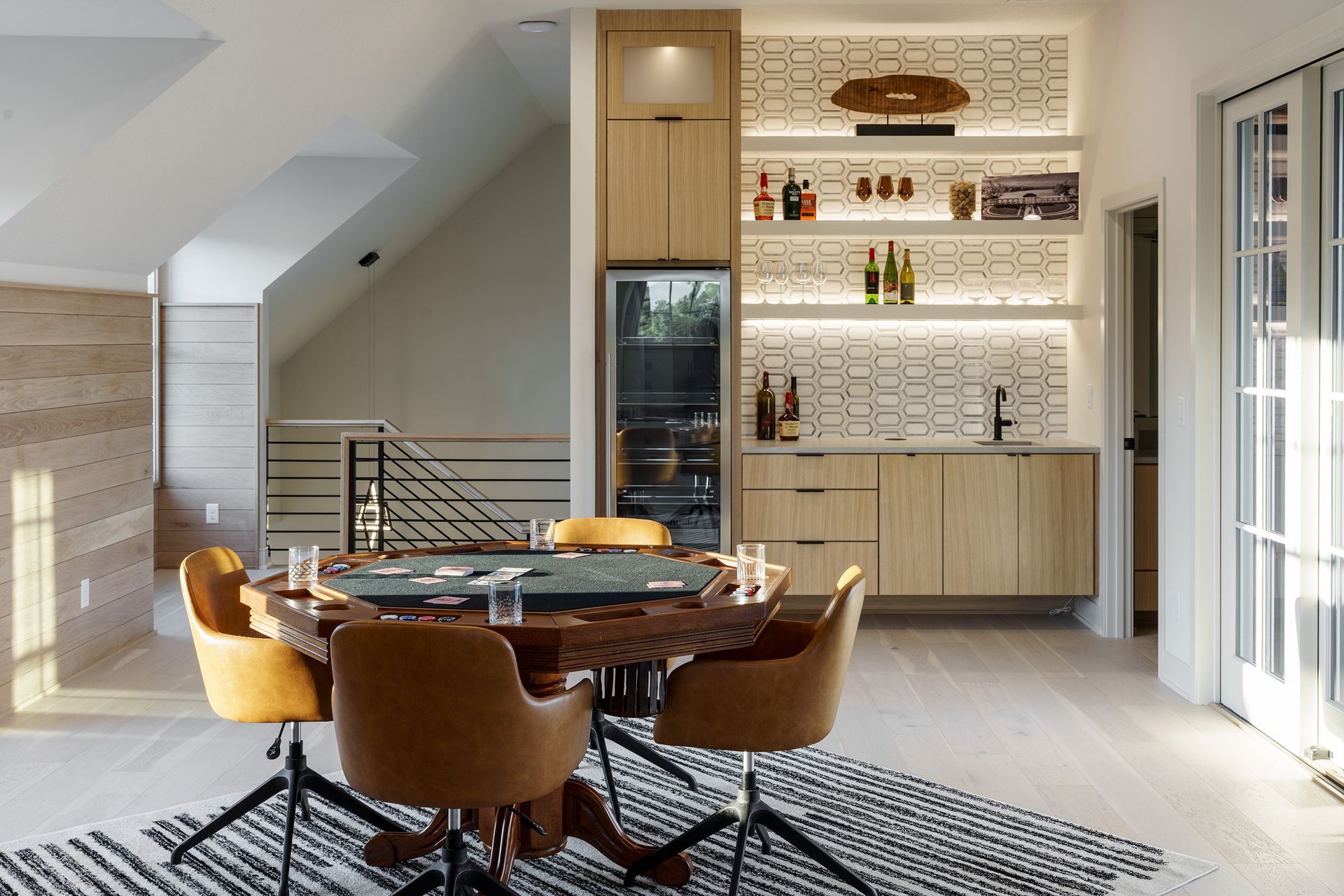 A game room with a table and chairs and a bar.