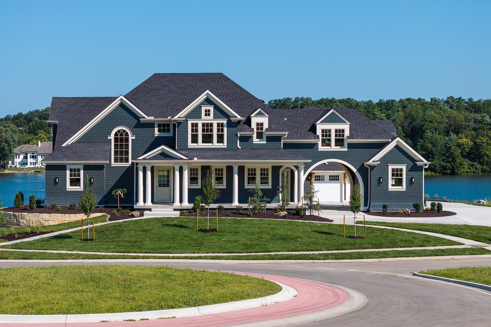 A large house is sitting next to a body of water.
