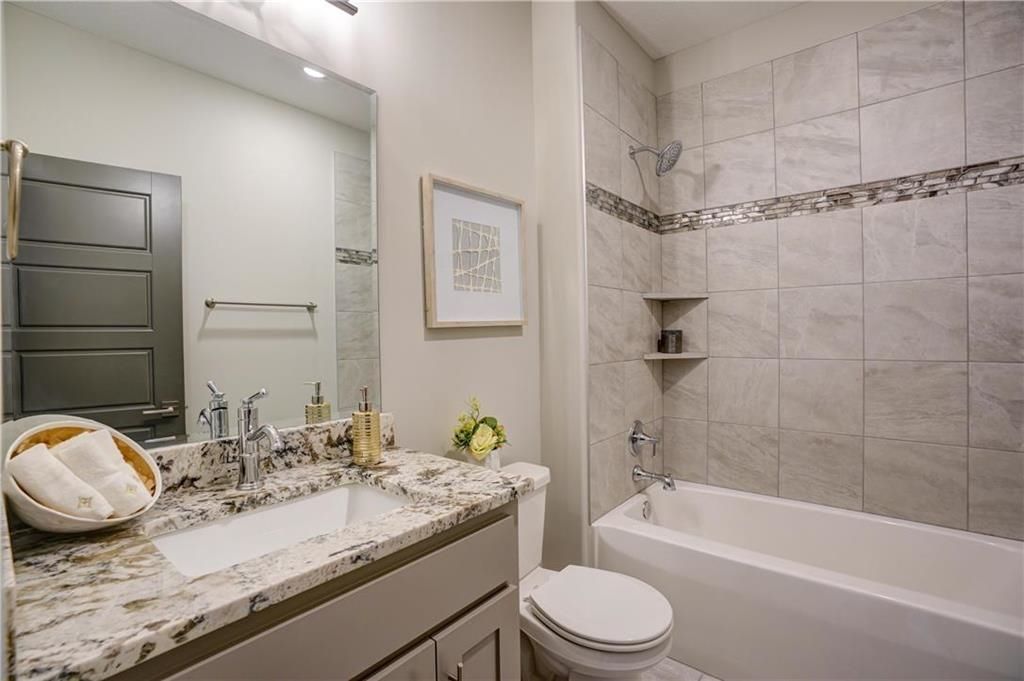 A bathroom with a sink , toilet , bathtub and mirror.