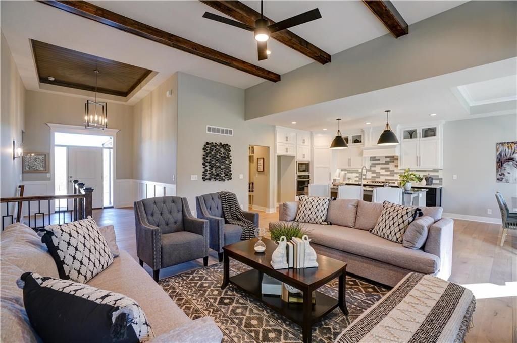 A living room with a couch , chairs , and a coffee table.