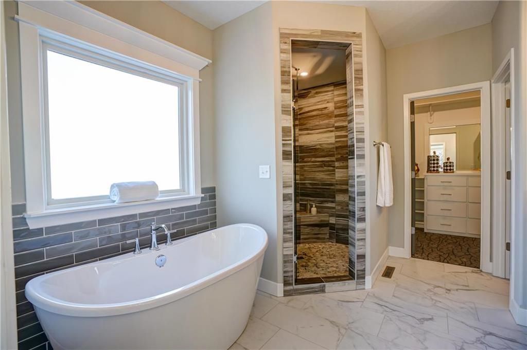 A bathroom with a tub and a walk in shower.