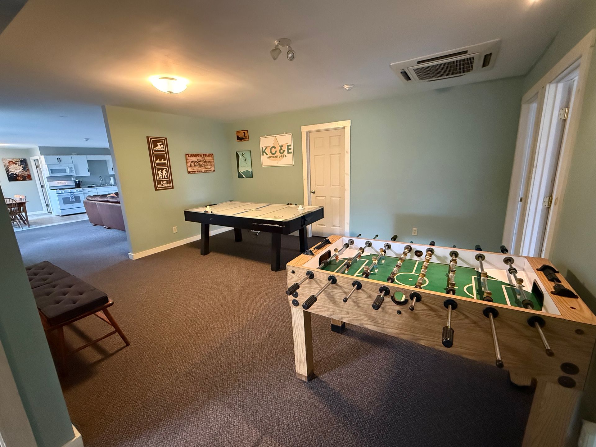 Recreation room with a foosball table, air hockey table, and wall art on light blue walls