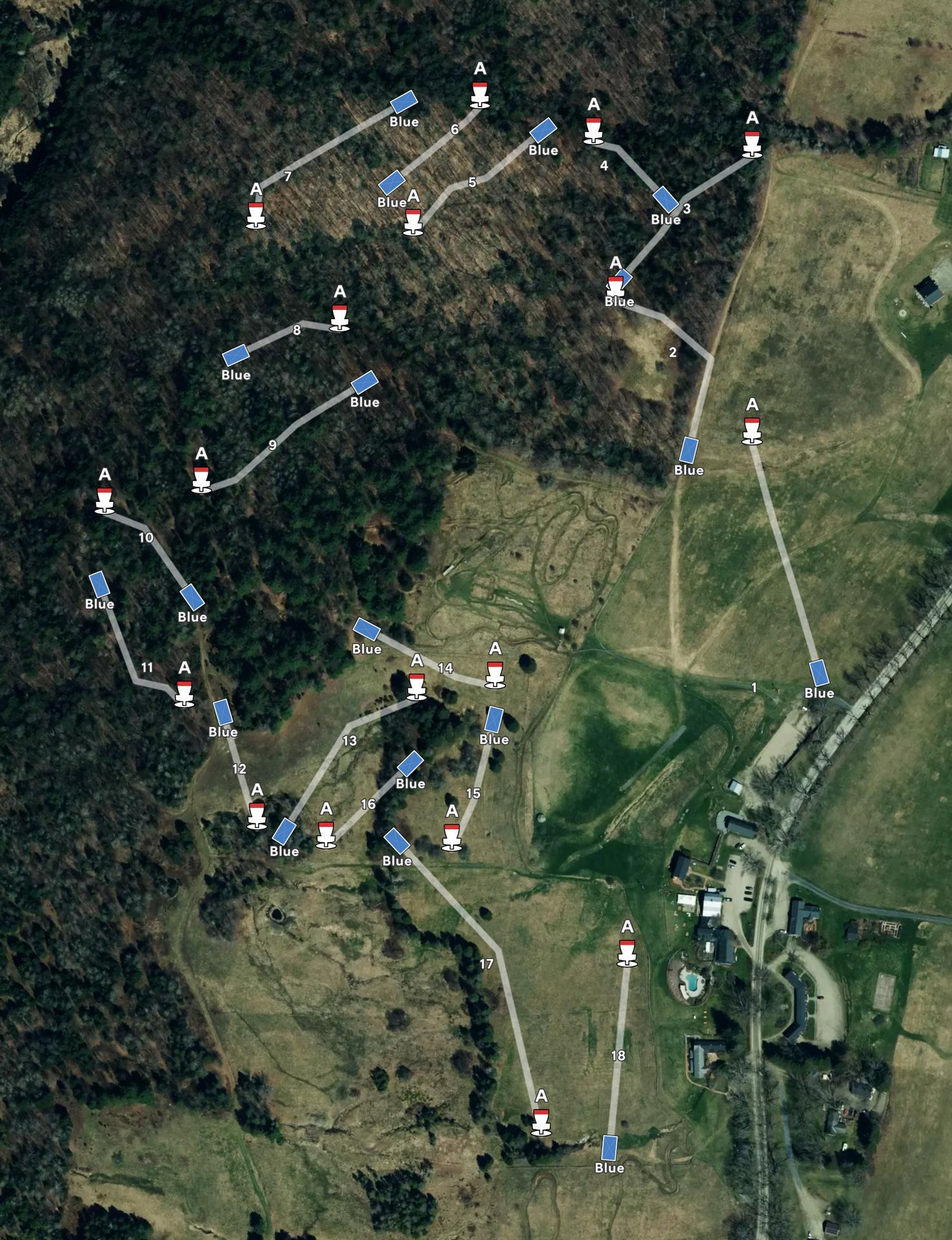 Aerial view of a forested hillside with a marked trail winding through trees and open grassland.
