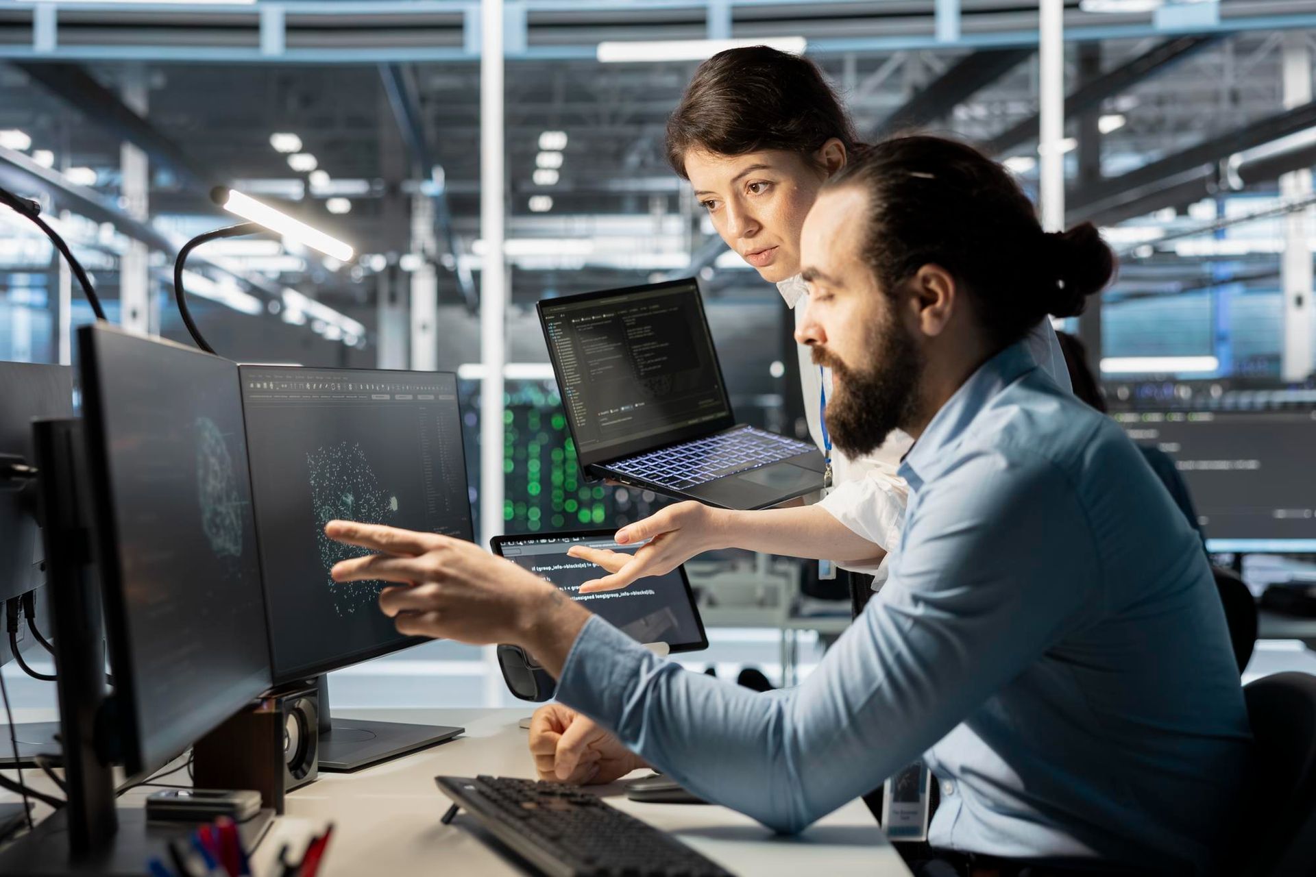 A man and a woman are looking at a computer screen.