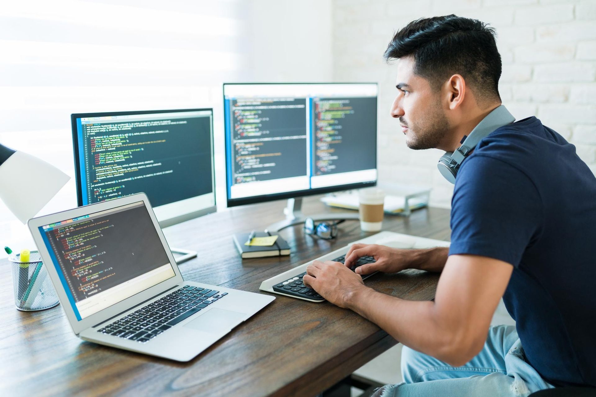 A man is sitting at a desk using a laptop computer.