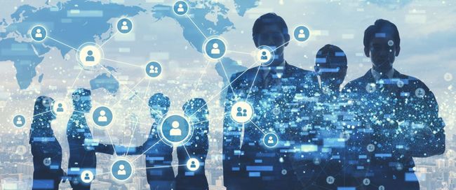Silhouetted business people shaking hands, overlaid with networking icons and a world map.