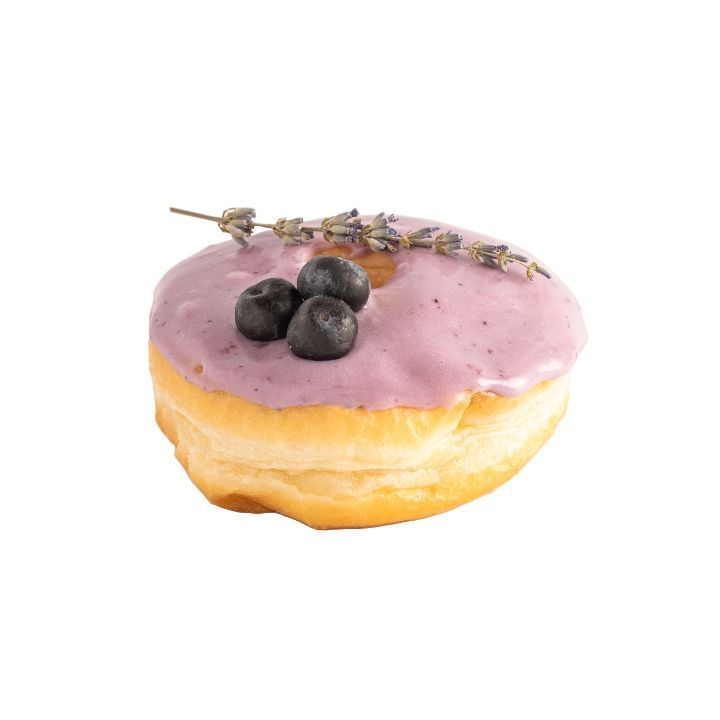 Donut with lavender-blueberry glaze, decorated with fresh blueberries and lavender sprig.