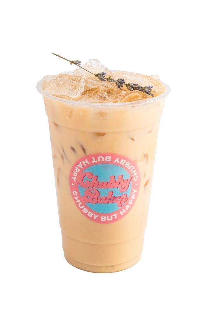 Iced coffee in a clear cup with lavender garnish and pink logo that says 