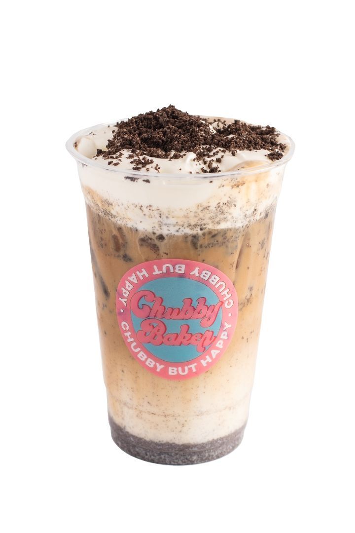 Iced coffee drink with cookies and cream topping in a clear plastic cup, featuring a bakery's logo.