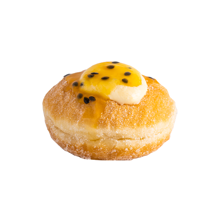 A sugared doughnut topped with yellow passion fruit filling and black seeds.