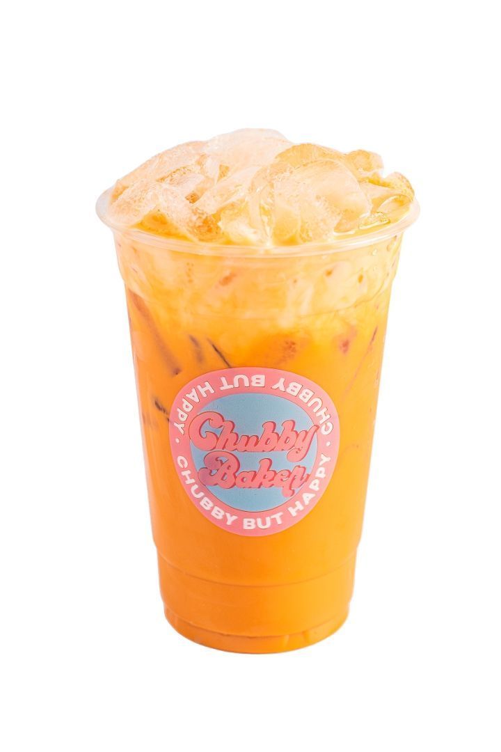 Iced Thai tea with frothy foam in a clear plastic cup, with a pink and blue logo that says 