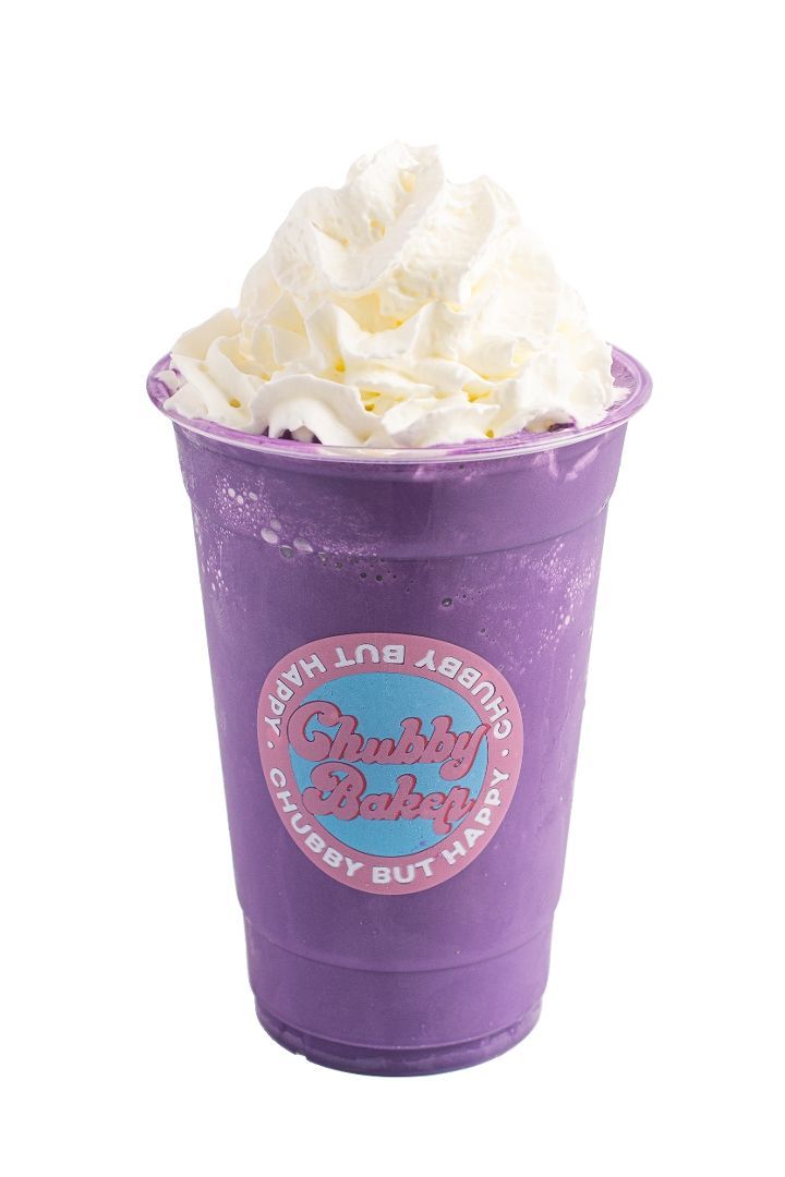 Purple milkshake in a clear cup topped with whipped cream; 