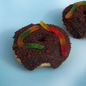 Apple fritter with glaze on a white background. The fritter is golden brown with visible chunks of apple.
