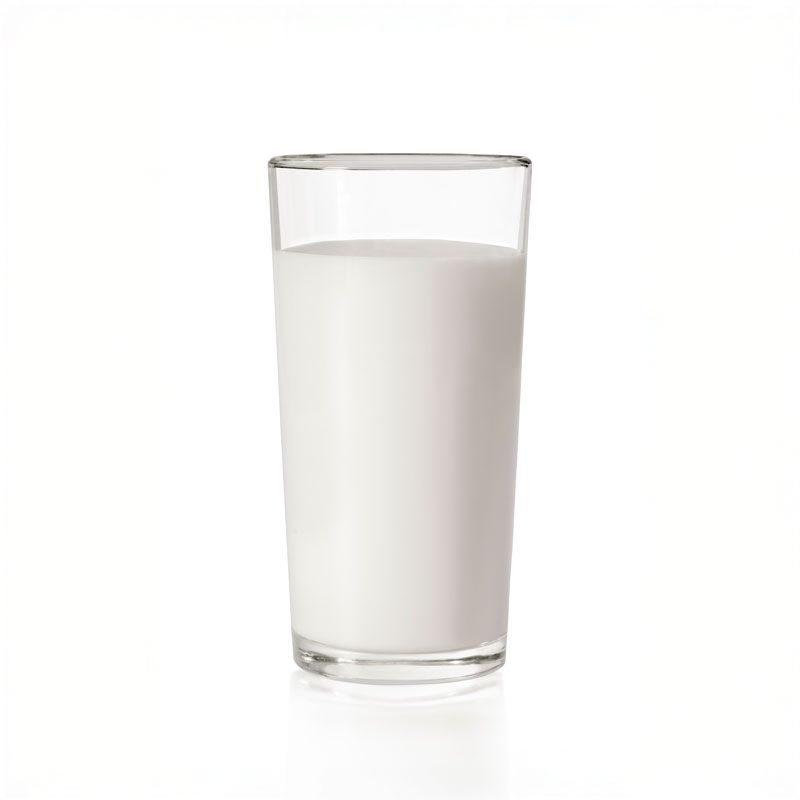 Glass of milk, mostly full, on a white background.