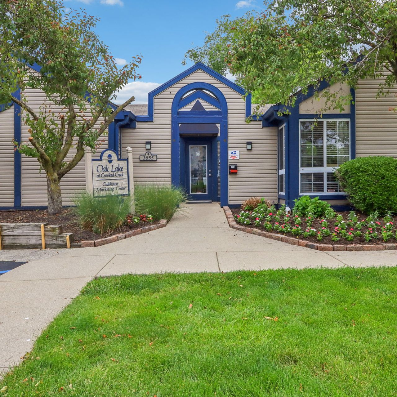 Office building with blue trim and landscaping. 