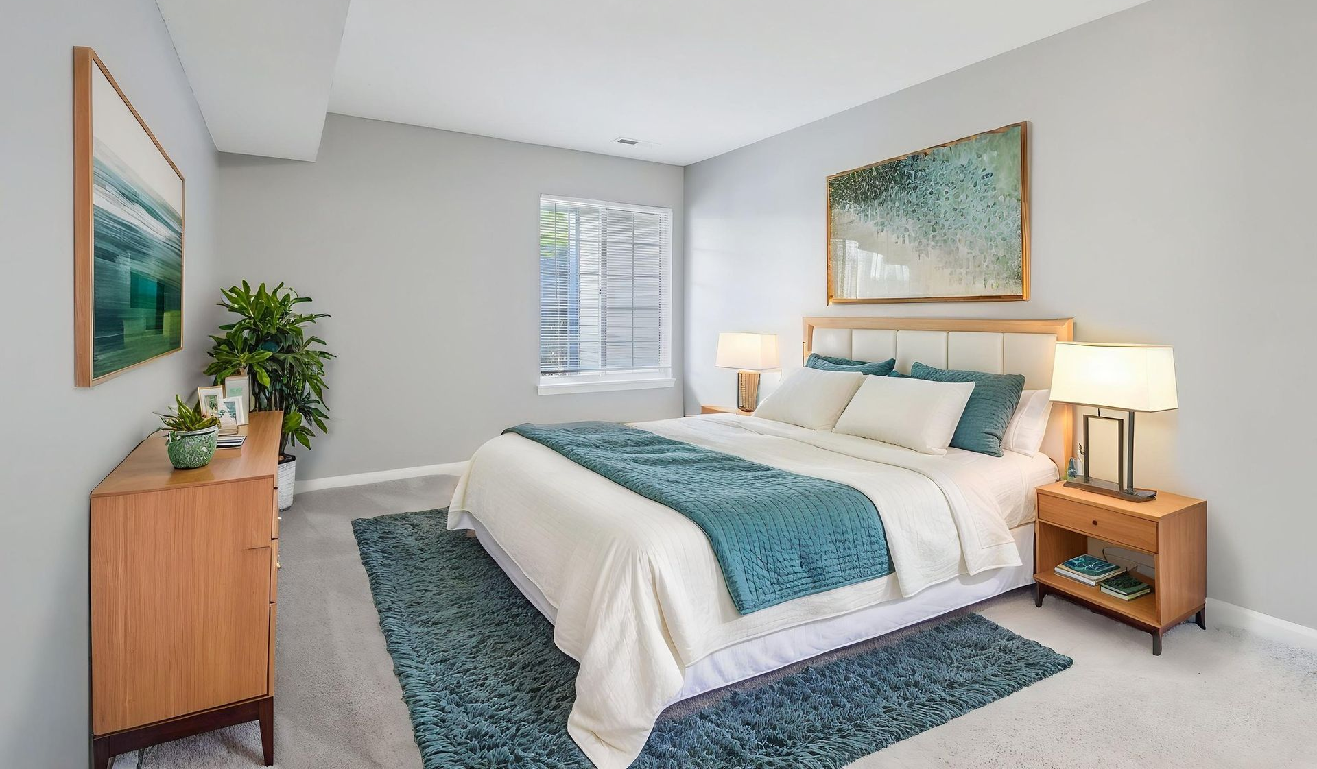 Bedroom with a bed, bedside tables, and artwork. Teal and beige color scheme.