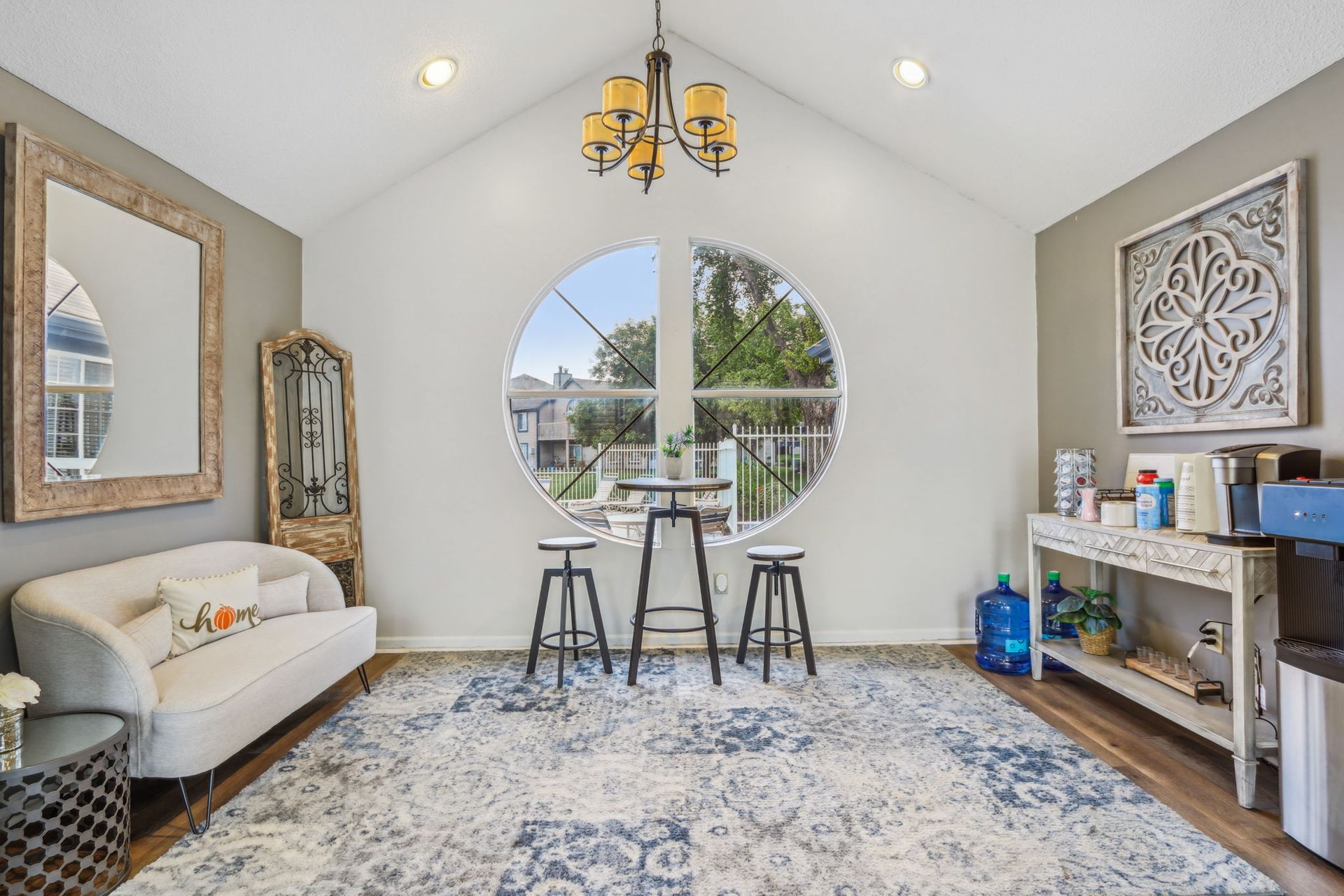 A bright, airy room with a round window, seating area, and decorative accents.
