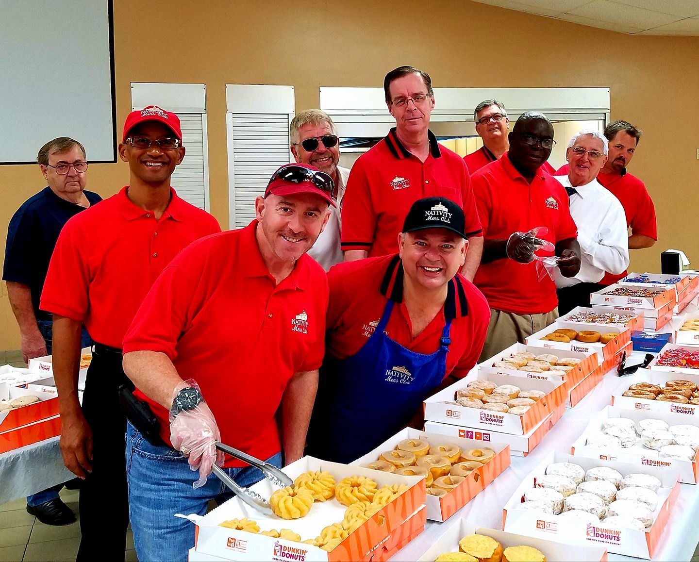 Image of men in red polos serving food
