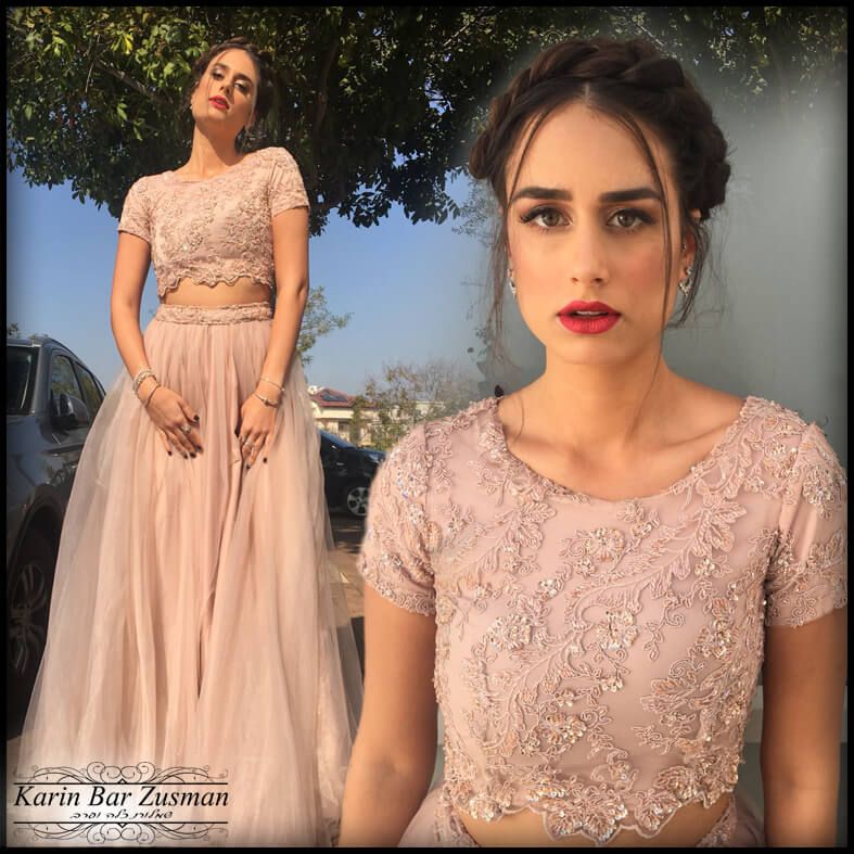 אישה בלבוש רשמי ורוד, מצטלמת בחוץ. לשמלה מחוך תחרה וחצאית טול.