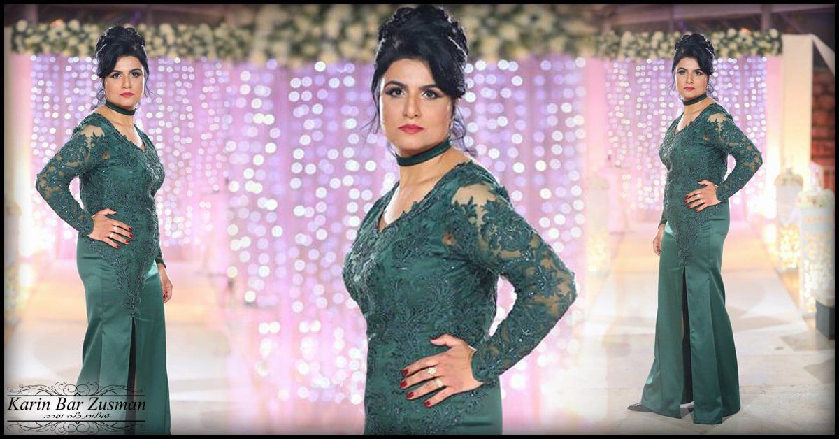 אישה בשמלה ירוקה מצטלמת על רקע דקורטיבי.