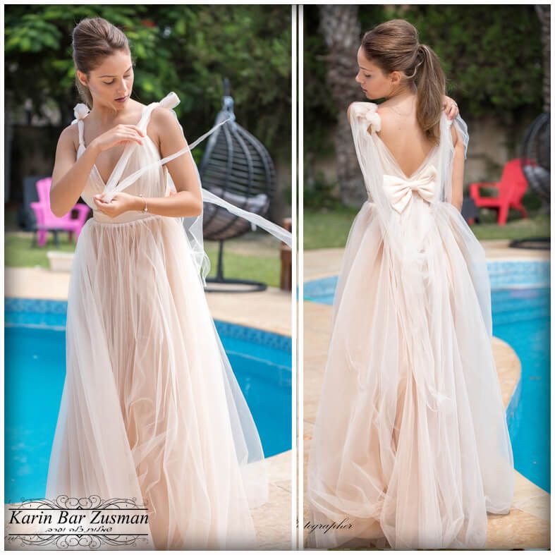 אישה בשמלה סומק זורמת, מסדרת את הרצועות ליד הבריכה, עיטור קשת בגב.