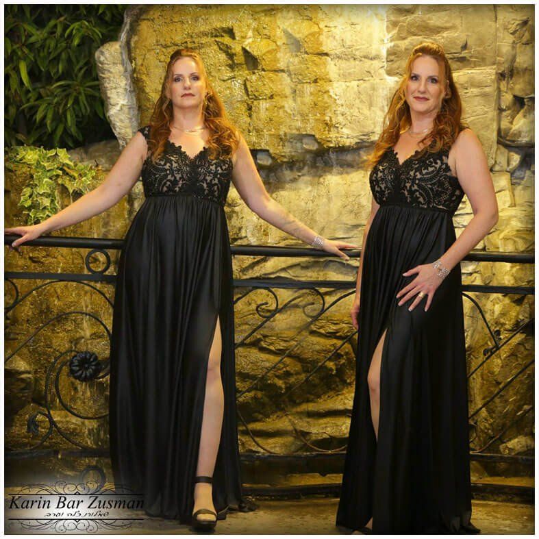 שתי נשים בשמלות רשמיות שחורות מצטלמות על מרפסת, ליד קיר אבן.