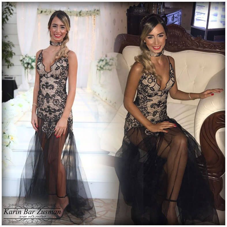 אישה בשמלה רשמית, יושבת על ספה. שמלת תחרה שחורה ובז' עם חצאית שקופה. מחייכת.