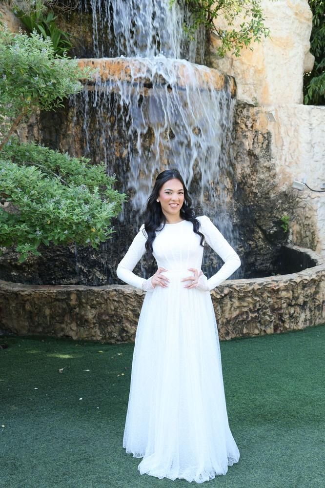 שמלת כלה צנועה מתחרה  ליד מפל טבעי
