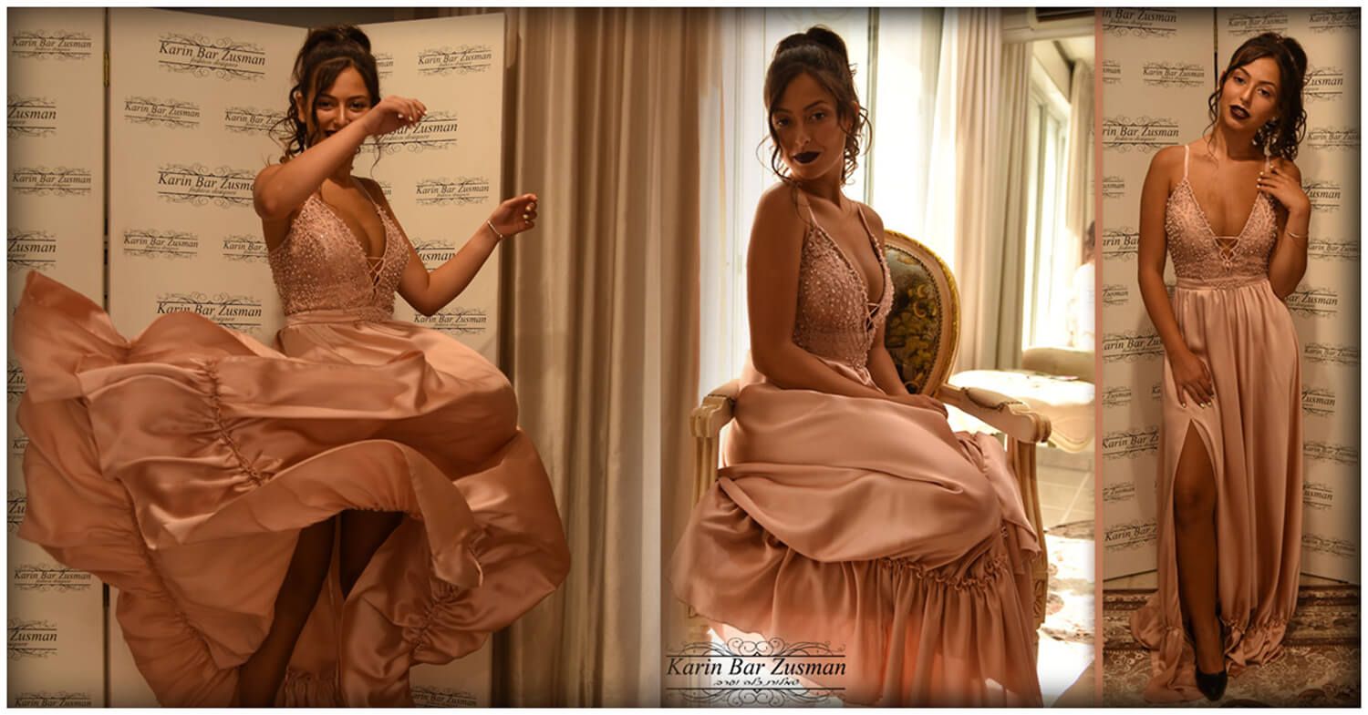 אישה בשמלה ורודה, מצטלמת בחדר עם רקע תווים, כיסא ואור שמש.