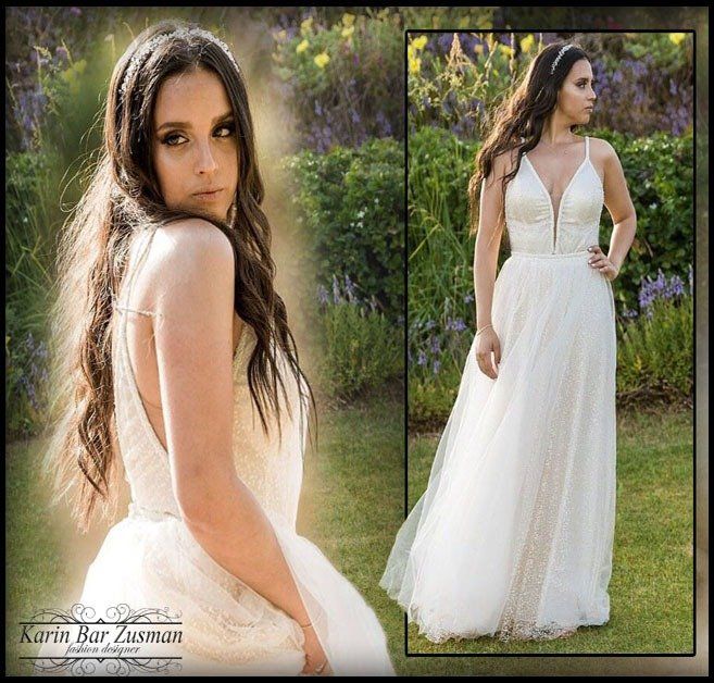 אישה בשמלה לבנה, בחוץ, מביטה לעבר הצופה בהבעת פנים מהורהרת.