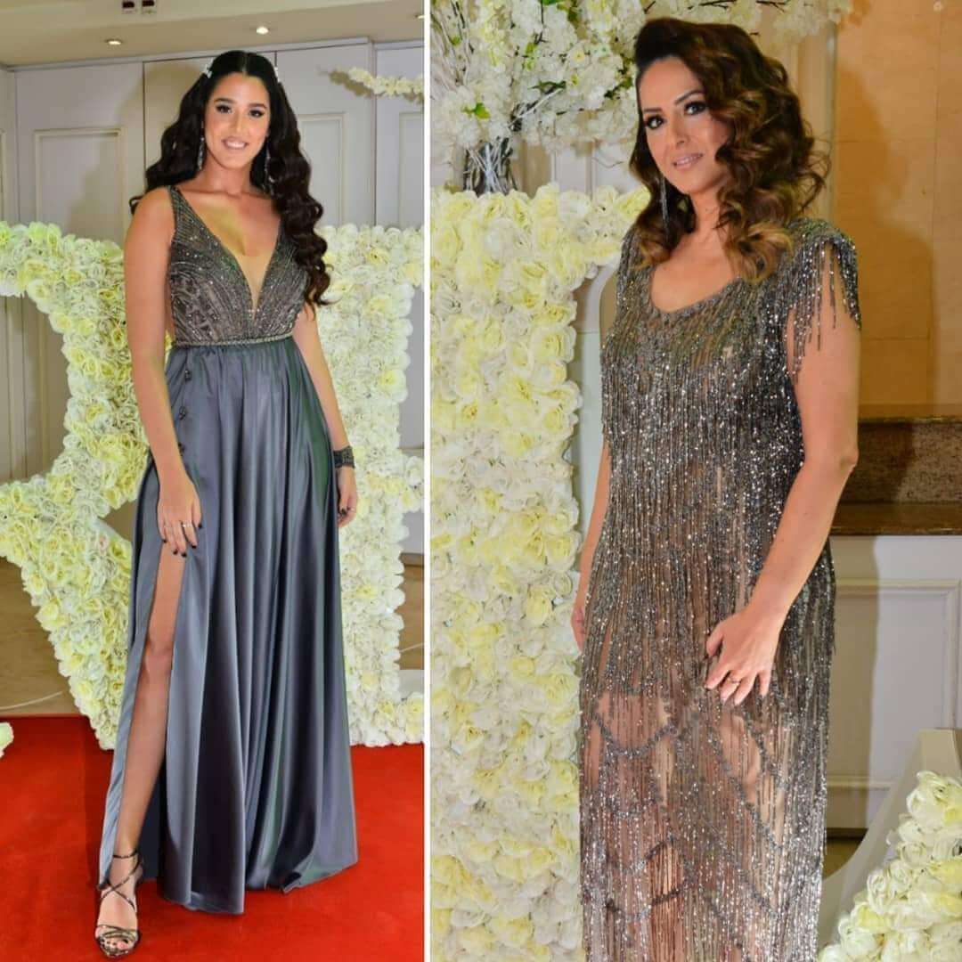 אישה בשתי שמלות חרוזים שונות על שטיח אדום. אחת אפורה עם שס בירך; השנייה עם פרנזים.