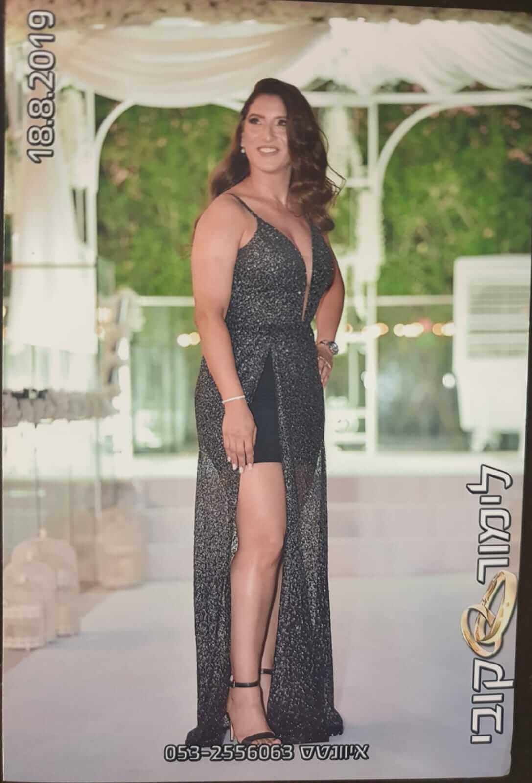 אישה בשמלה שחורה נוצצת מצטלמת באירוע בחיק הטבע, תאריך 18.8.2019 גלוי.