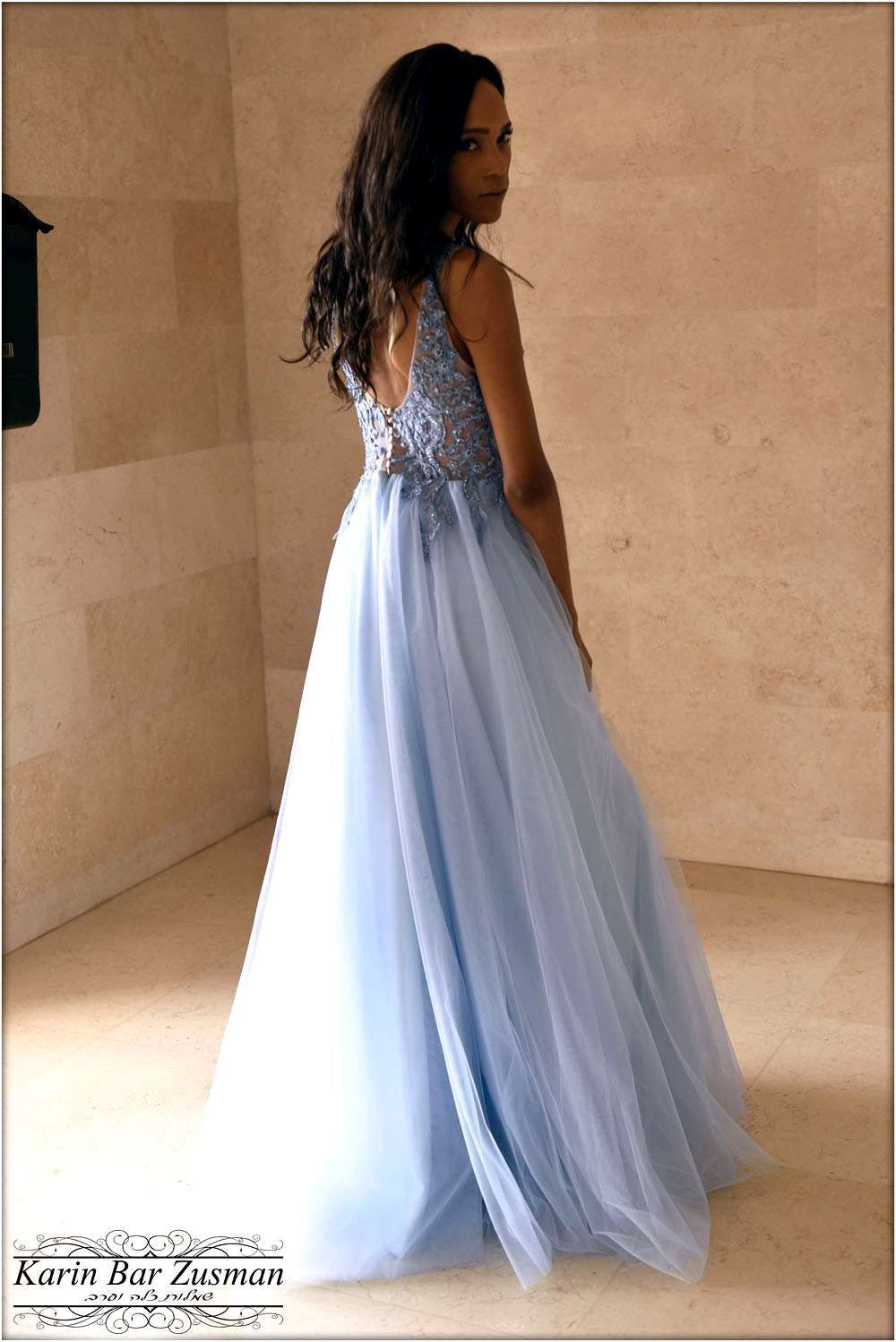 שמלת ערב כחולה בהירה עם גב פתוח וחצאית טול נשפכת בעיצוב קארין בר זוסמן