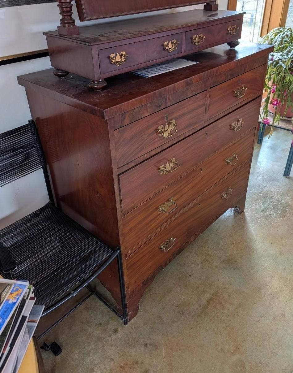 Dark wood dresser with brass handles.