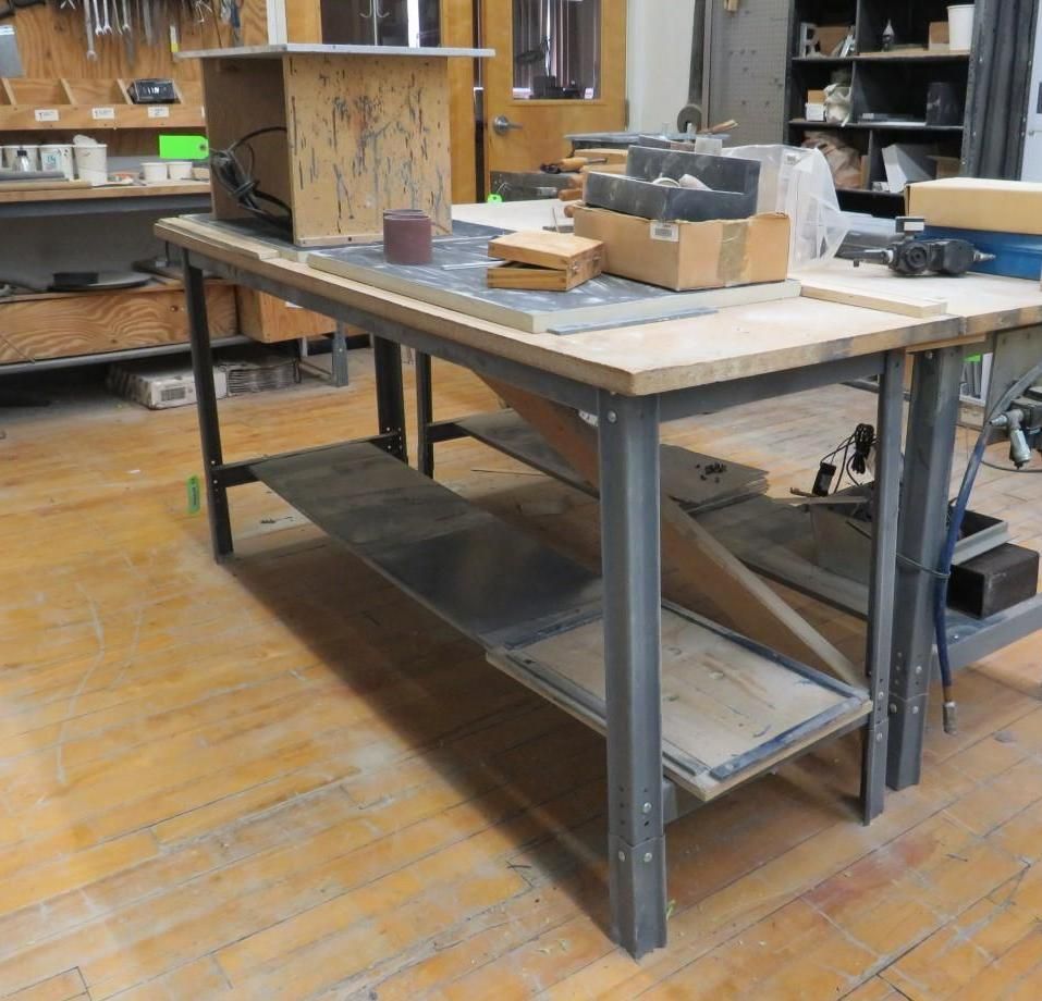 Workbench with metal frame, wood top, and two shelves.