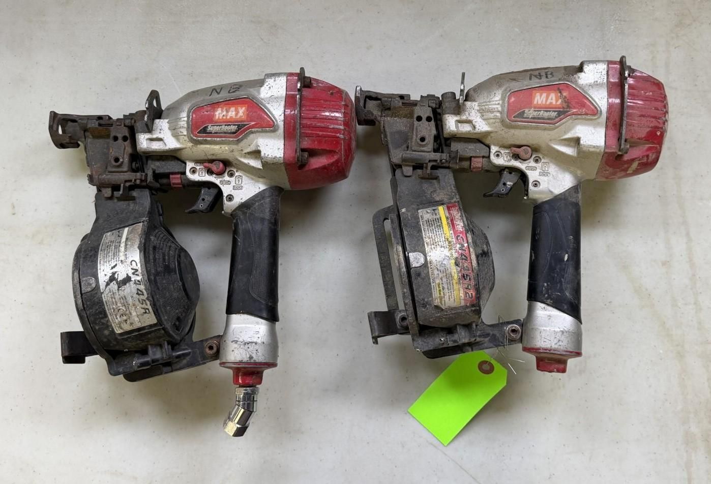 Two pneumatic nail guns, red and silver, with black handles and nail feeders, resting on a surface.