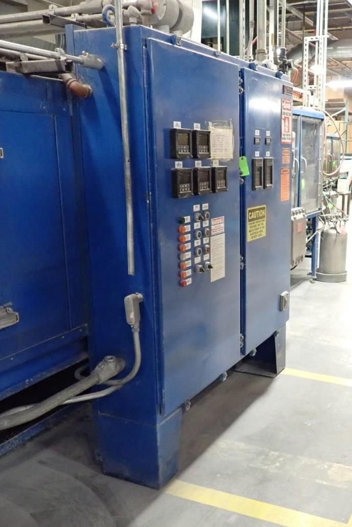 Blue industrial oven with control panel in a factory setting.