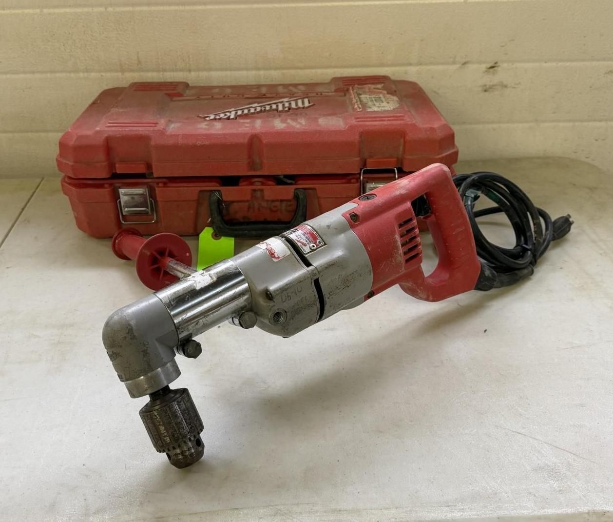 Milwaukee right angle drill and red case on a white surface.
