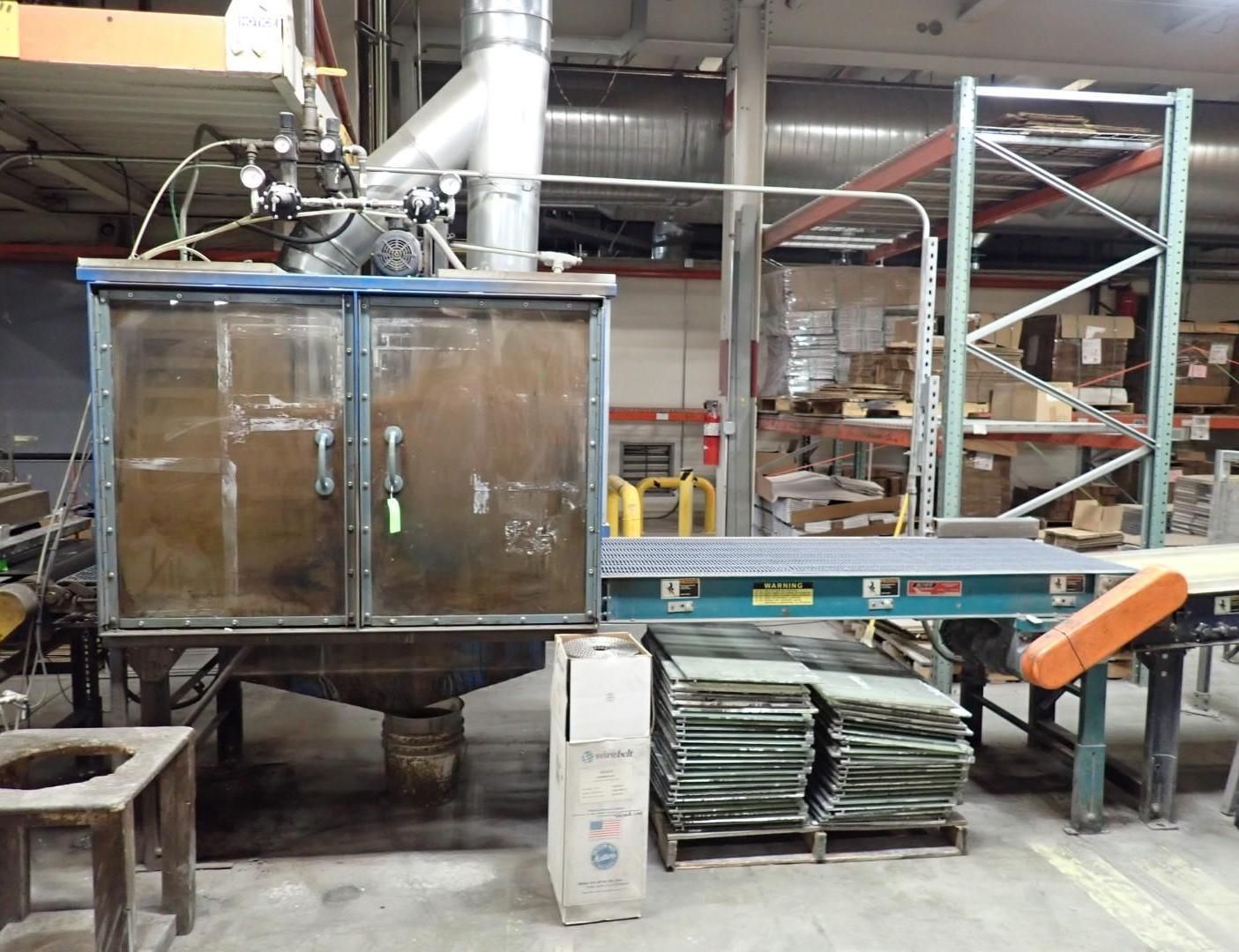Industrial cabinet with ventilation, conveyor belt, and stacked glass panels in a warehouse.