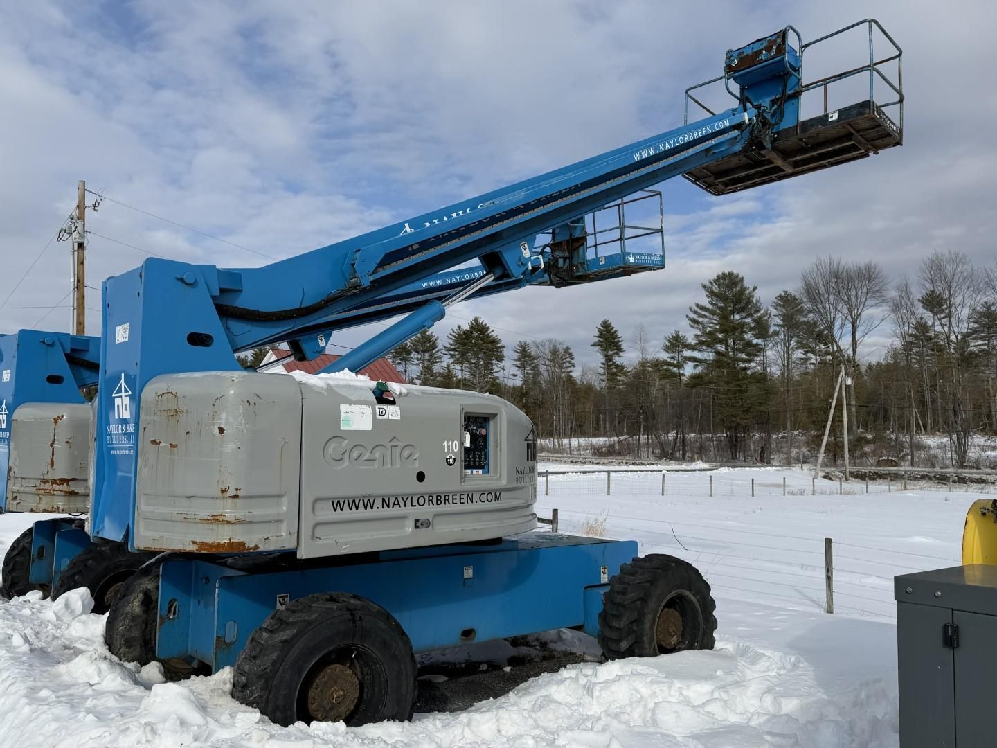 Blue Genie articulating boom lift in a snowy field.
