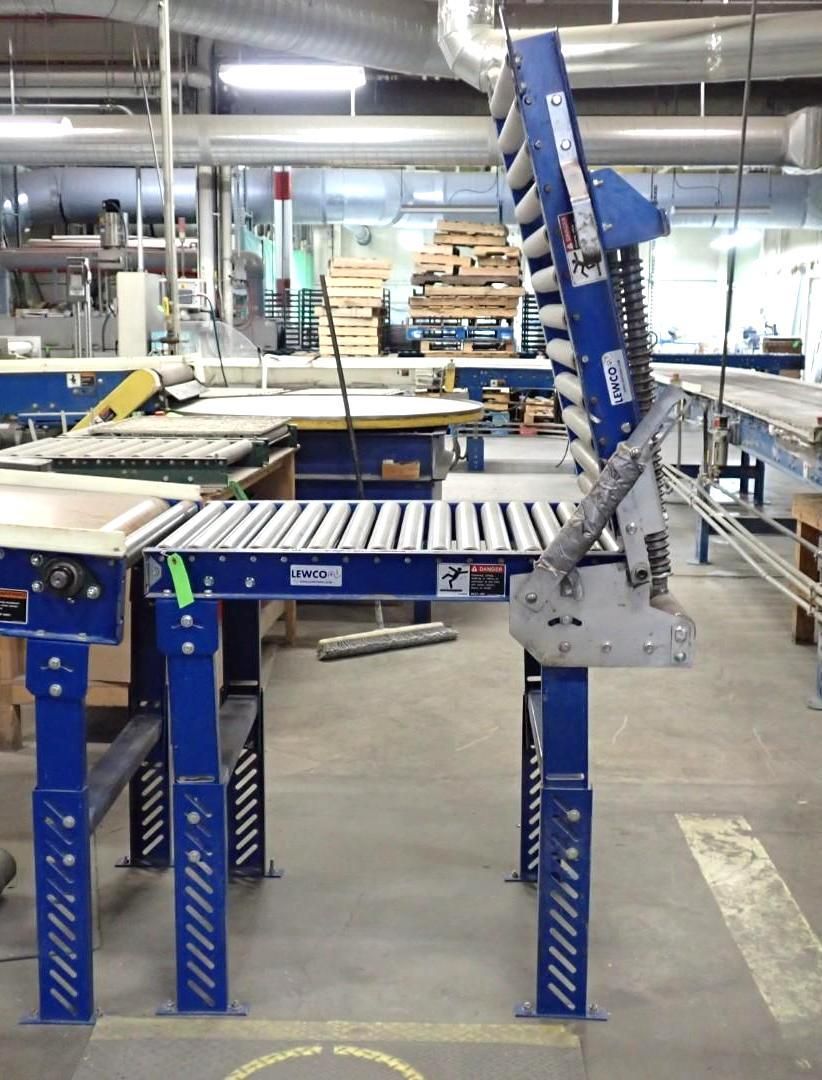 Blue industrial conveyor system with rollers, in a factory setting.