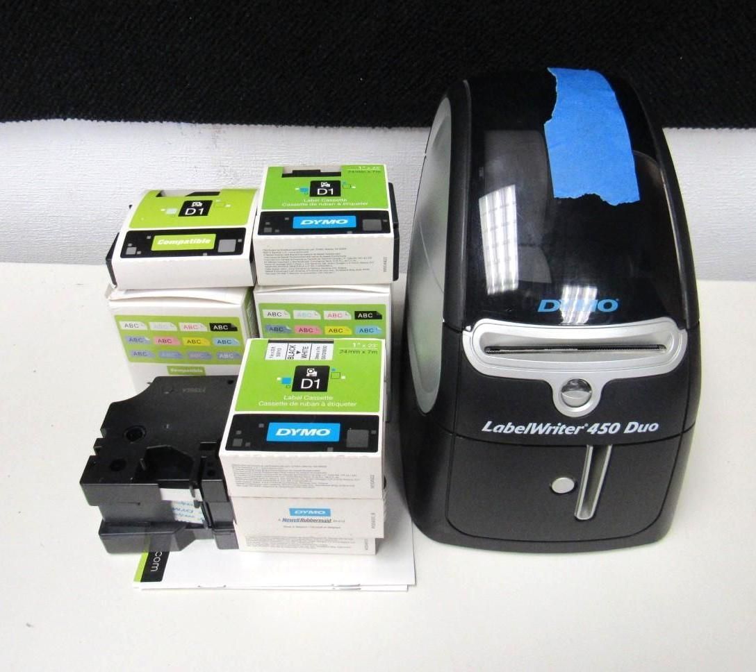 Label maker and label cartridges on a white surface, with a black and blue label printer.