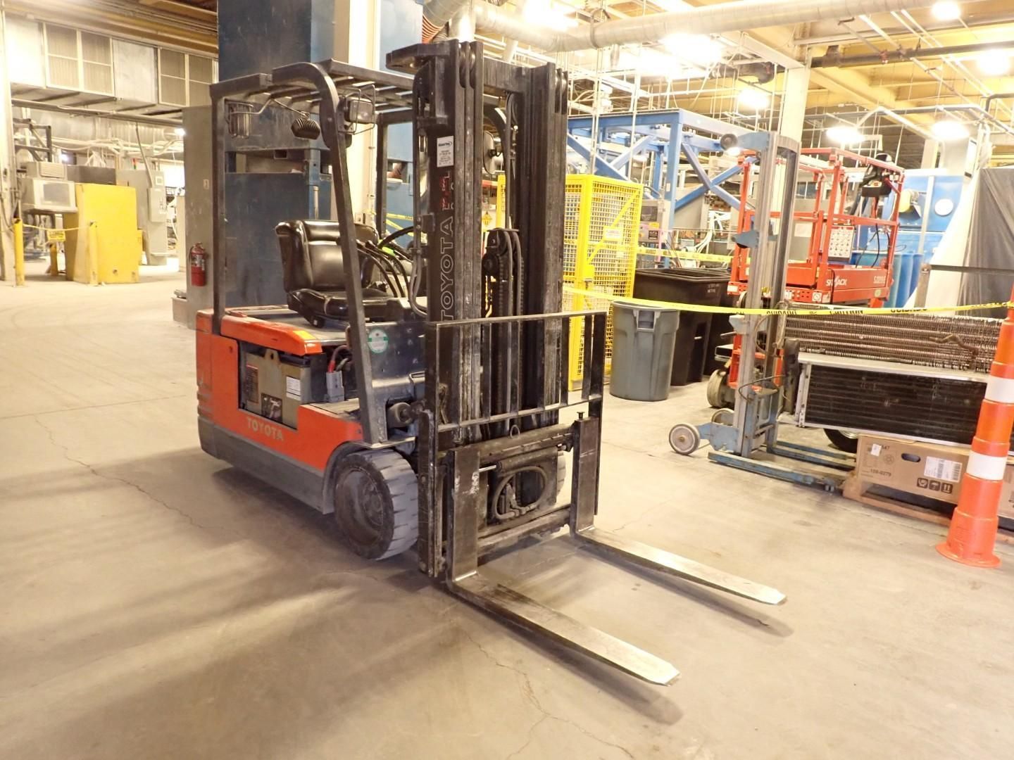 Forklift in a warehouse setting, with a long, metallic fork.
