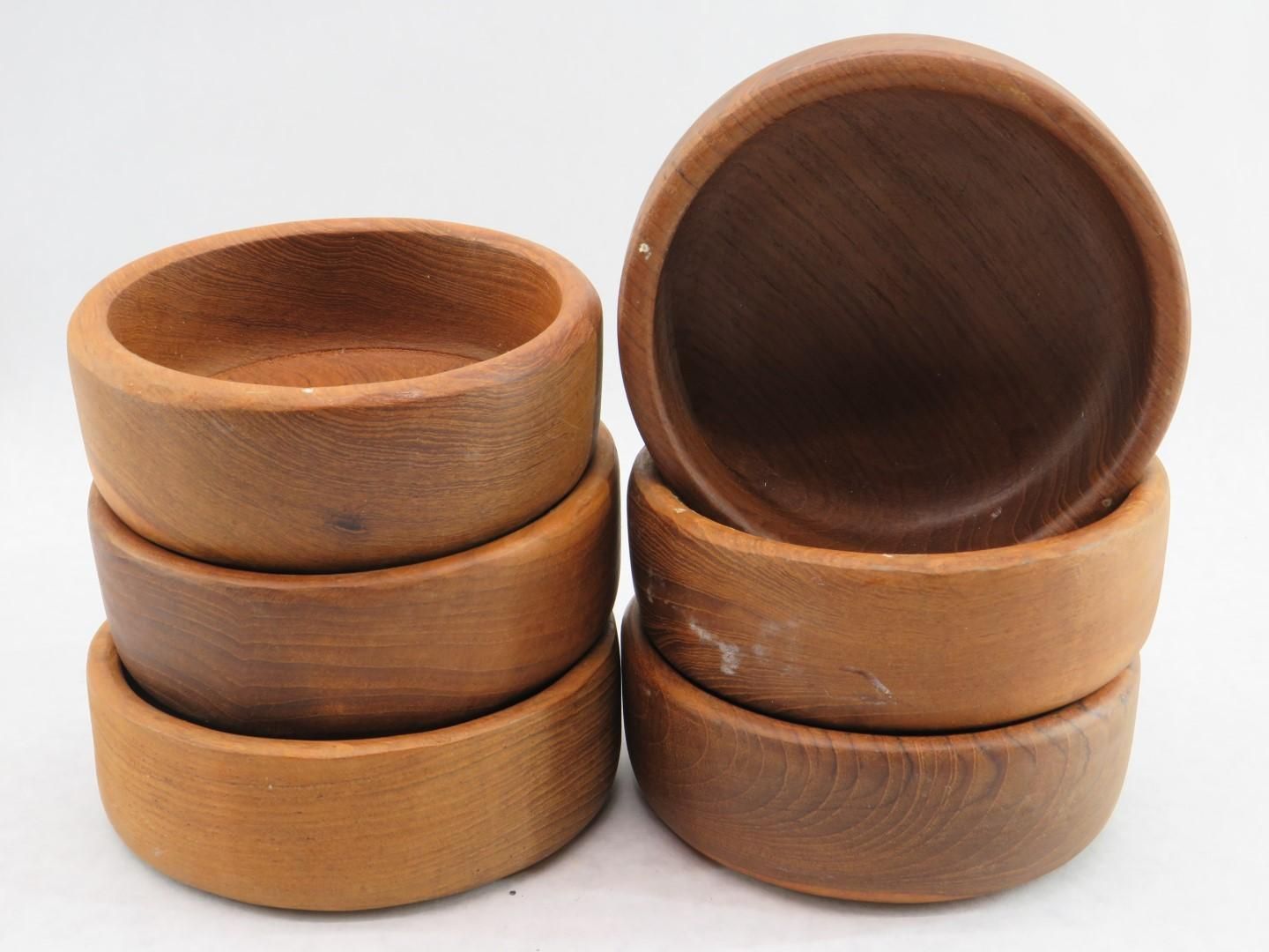 Six wooden bowls stacked, various shades of brown, against a white background.
